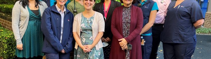 Group of smiling staff researchers near a garden