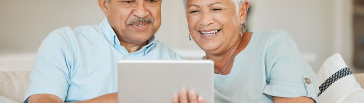 Two seniors holding a tablet 
