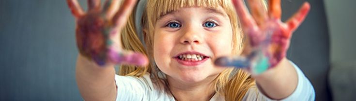 Young girl with paint on her palms smiling