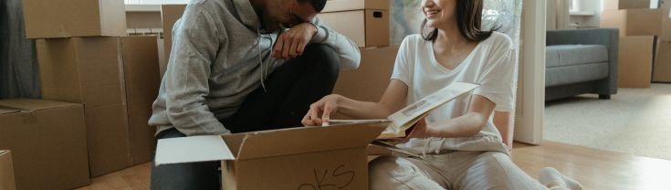 A couple sat on the floor with a moving box