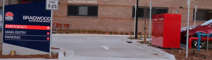 Main entry to the Braidwood Multipurpose Service. A sign indicating the main and emergency entry points is on the left side of the image.