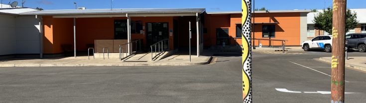 Main entrance to the Hillston Multipurpose Service. Two Aboriginal totem poles are sited near the driveway in the foreground of the image. 