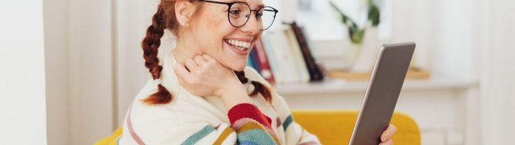 Woman smiling looking at computer tablet