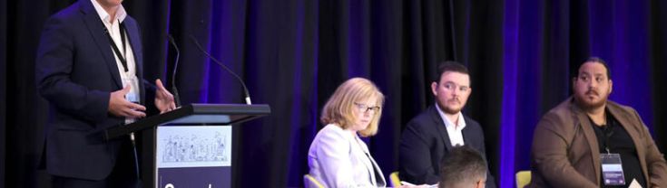 A facilitator and panel on stage in front of an audience at a SmartNSW Masterclass event.