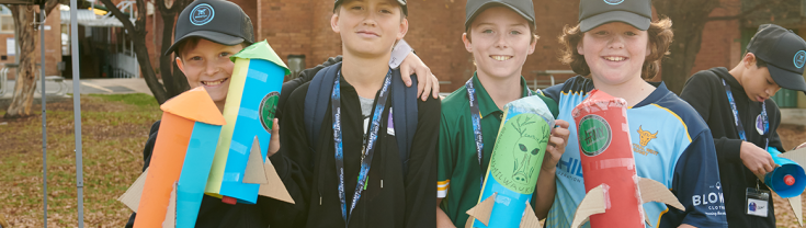 Young people smiling and holding rockets after attending a space camp in Mudgee NSW 