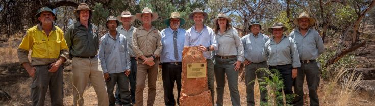 Park rangers and government officials opening the park, standing near the plaque marking the area as Aboriginal land. 
