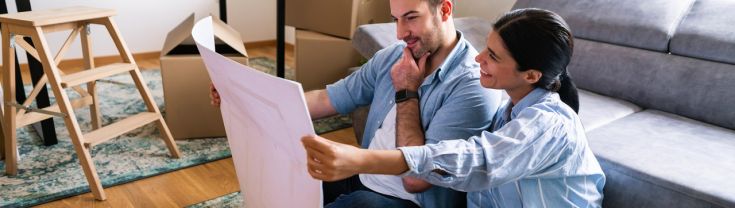 Couple looking at the blueprint while sitting on the floor