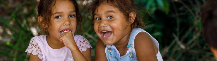 Two smiling Aboriginal girls looking at the camera