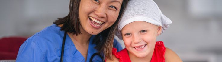 Doctor sits with a child patient who is fighting cancer.