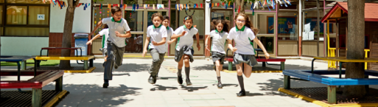 A photograph of primary school children running in the playground