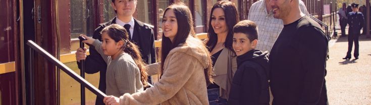 A family boards a heritage train carriage