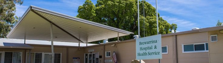 Entry to Brewarrina multipurpose service with green grass and flags