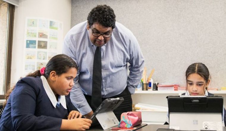 Man in classroom with students on their tablets