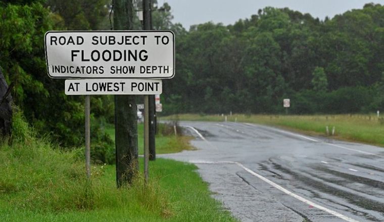 The Hawkesbury-Nepean Valley Flood Evacuation Road Resilience sign and road on wet rainy day