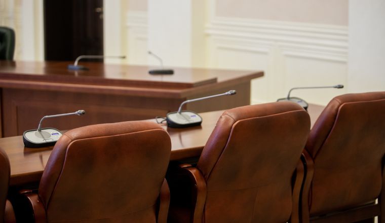 A meeting room with brown leather chairs and a microphone