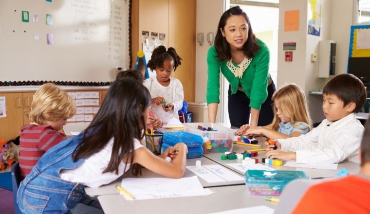 Female teacher in a classroom with young children.