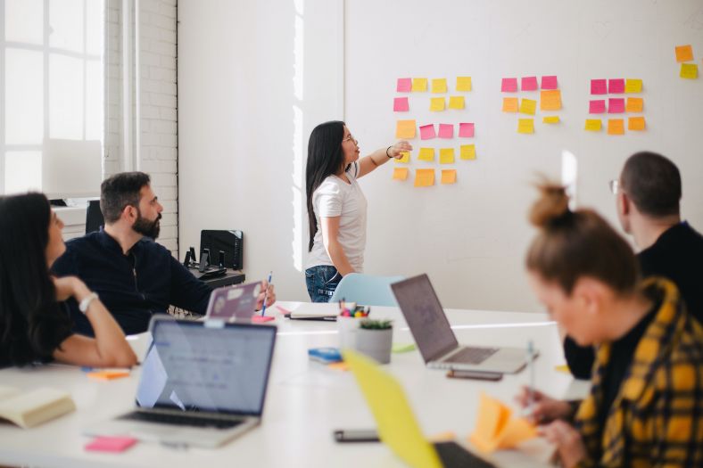 Woman standing in front of a board with post-it notes