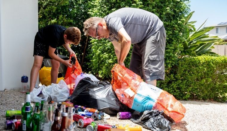 A young boy and his father counting bottles and cans for recycling.