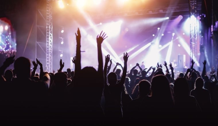 A crowd at a rock concert, with hands up in the air.