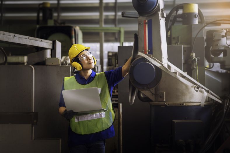 Image of a man in a factory testing mechanical equipment