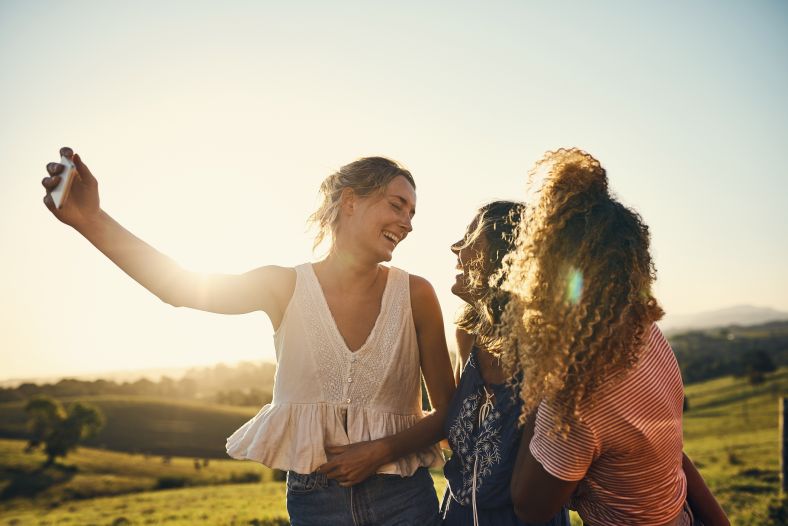 Three girls enjoying some time together outdoors in a rural setting.