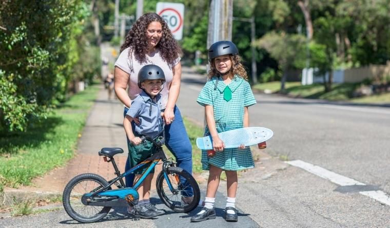 mother takes a boy and girl to school on a bike and skateboard in nsw