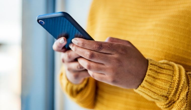 A woman using a mobile phone in her hands.