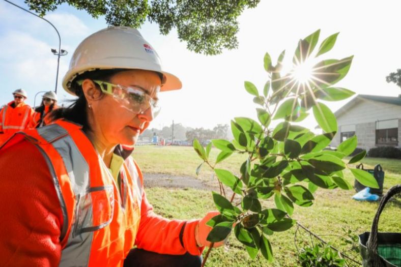 Woman doing landscape gardening in high viz safety gear