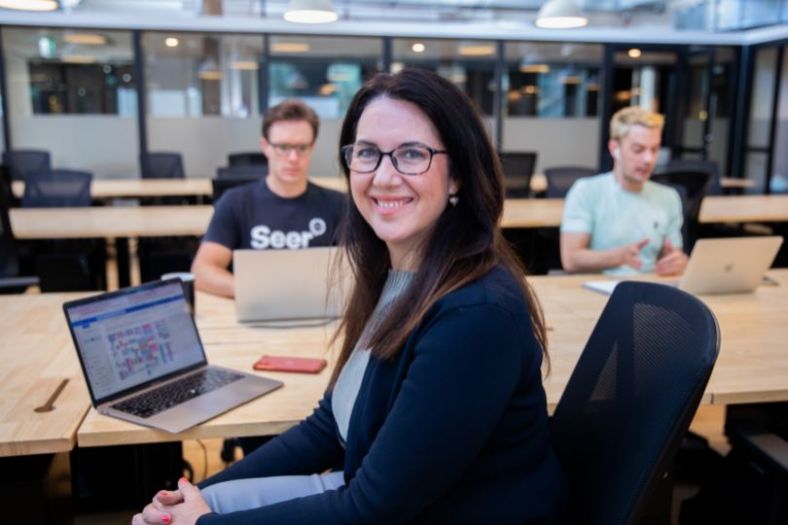 A woman at a start up leading a team in the office