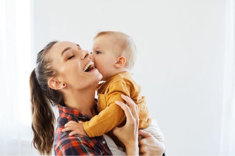 A woman smiling while holding her baby