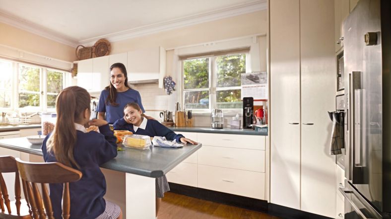 Mother preparing food with two girls in a kichen