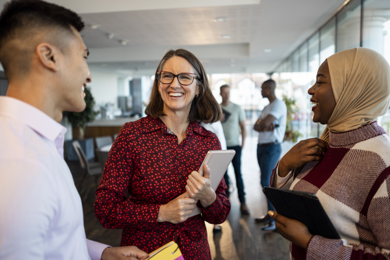 Woman talking to two people holding a tablet