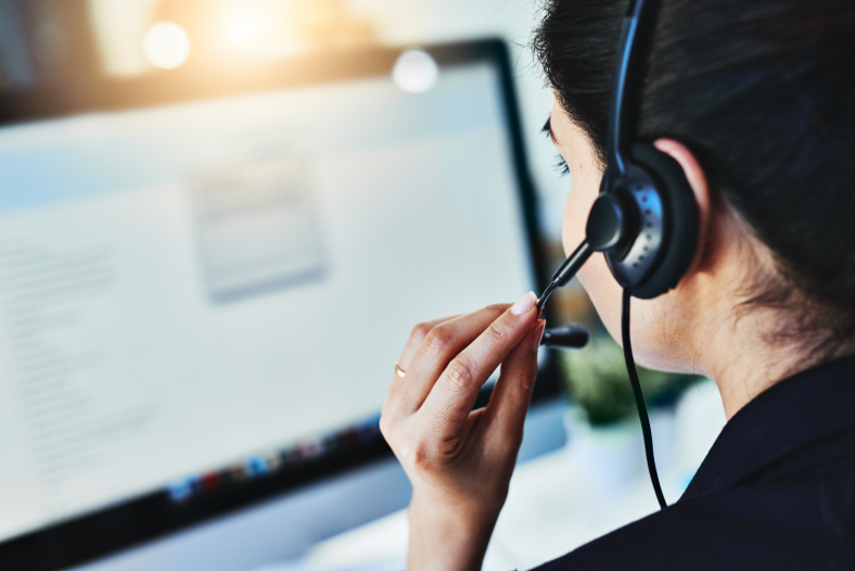 Woman wearing headset looking at computer screen