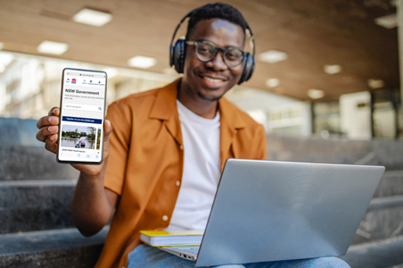 A man smiling, holding a smart phone