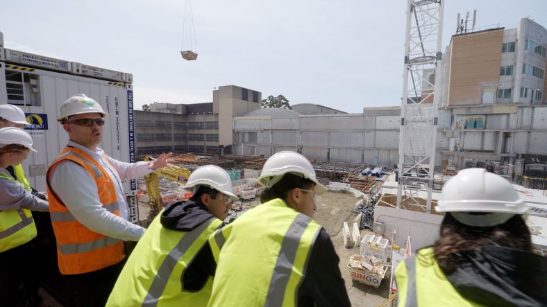 Group of high school students in PPE on construction site