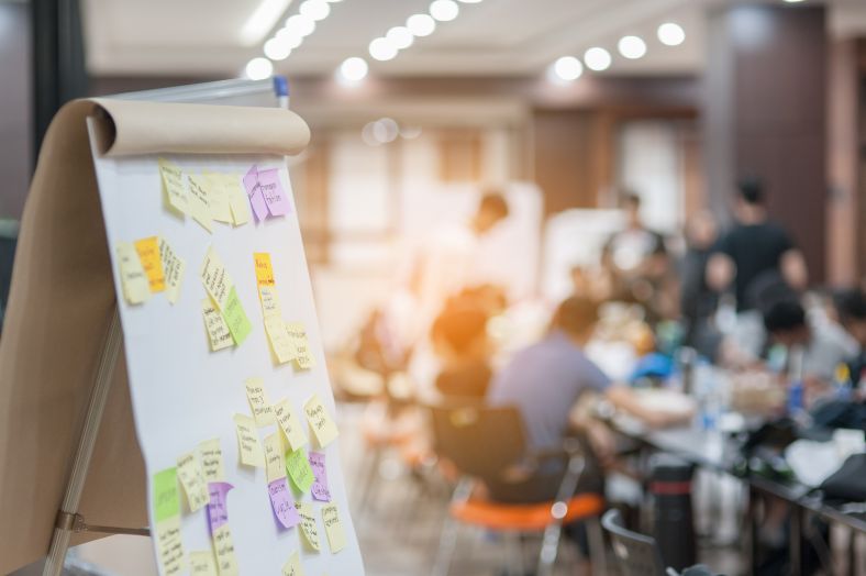 People meeting with post it notes on white board