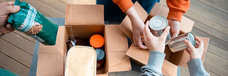 Cans and packaged food being put into boxes