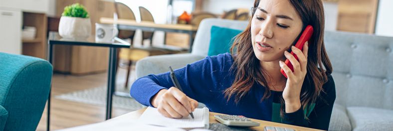 A woman looking at a piece of paper with a concerned look on her face 