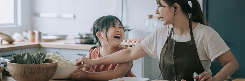 Lady cooking in kitchen with child