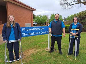 Three allied health professionals holding mobility aids and standing in front of Corowa Hospital