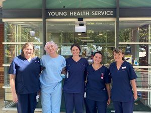 Image shows a group of new nursing graduates standing outside the hospital entrance at Young.