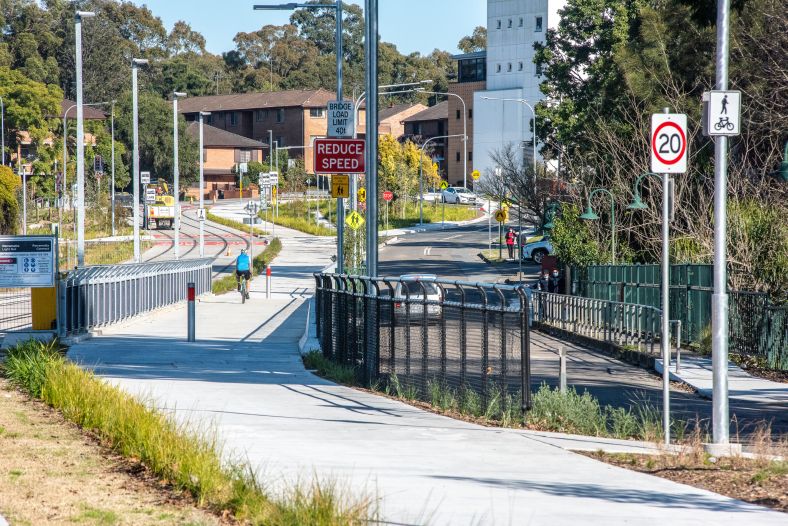 A lone bike rider enjoys a new shared path on a bright, sunny day.