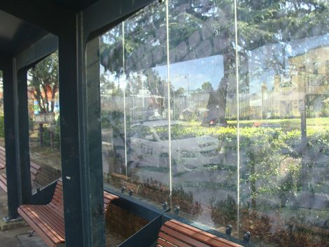 Bus shelter with protective film over glass