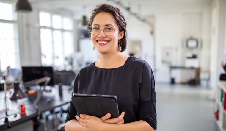 A businesswoman holding a tablet inside an office