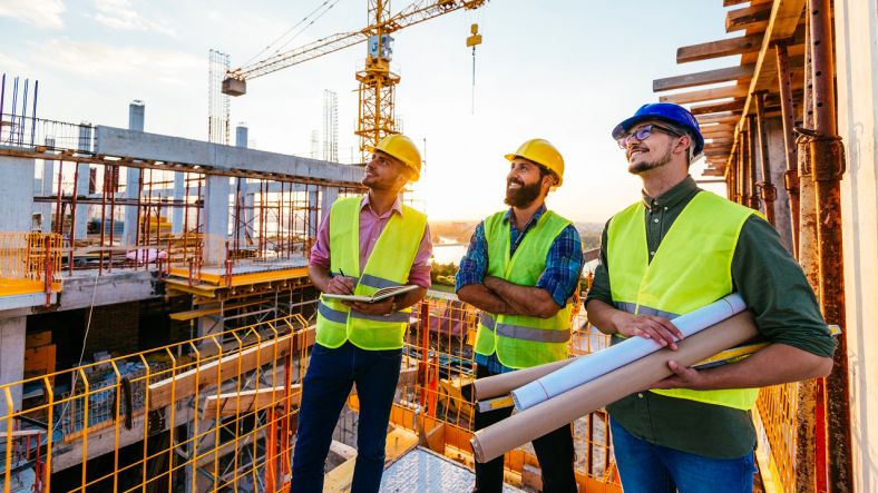 Building contractor with blueprint on a construction site