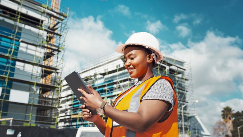 Woman using a digital tablet while working at a construction site