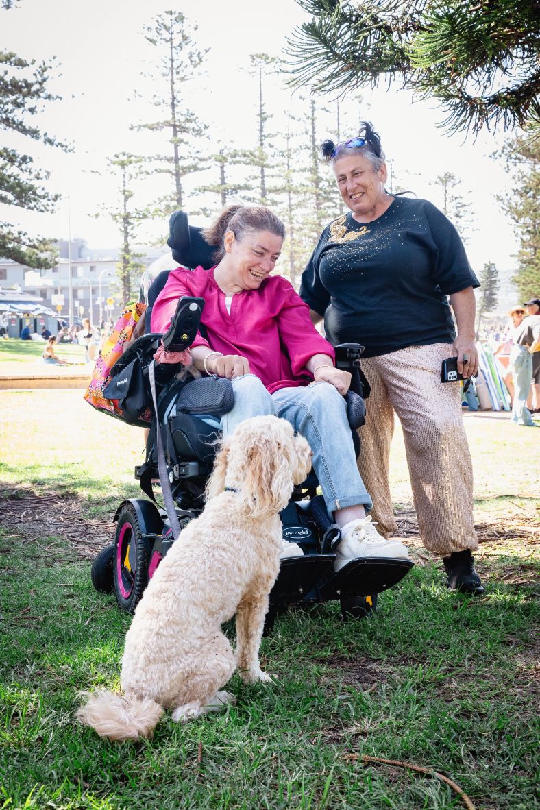 Woman in a wheelchair supported by a support worker