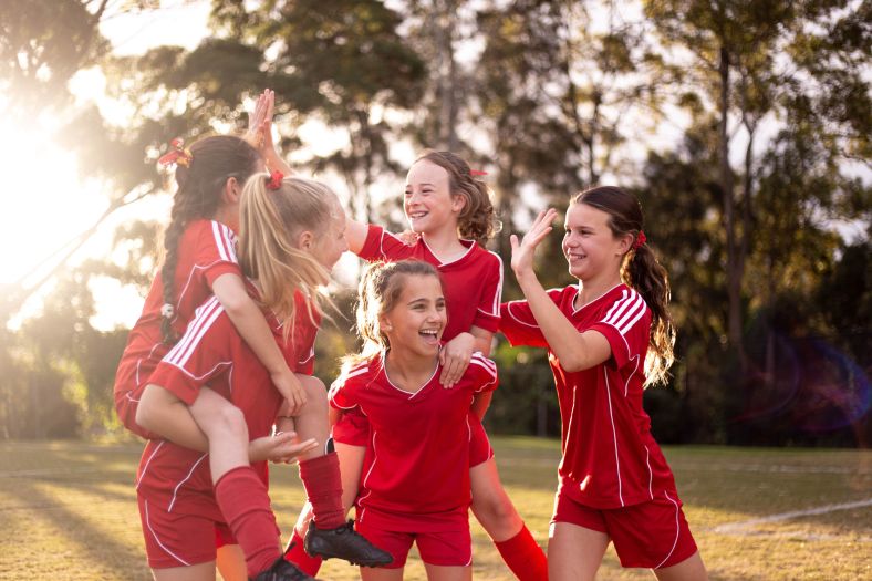 A team of young girls celebrating a goal