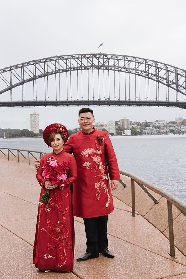 A couple pose in front of the harbour bridge.