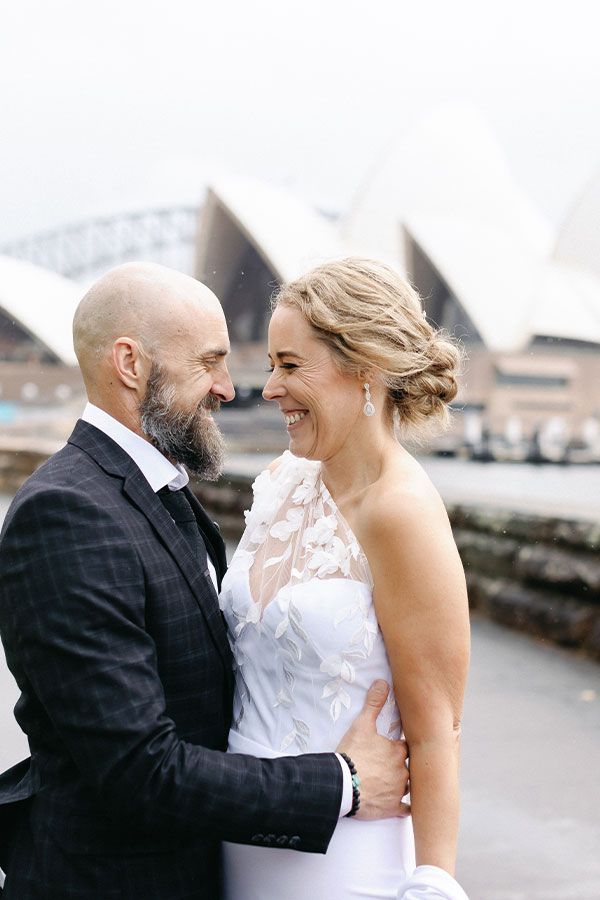A couple embrace with the Sydney Opera House in the background
